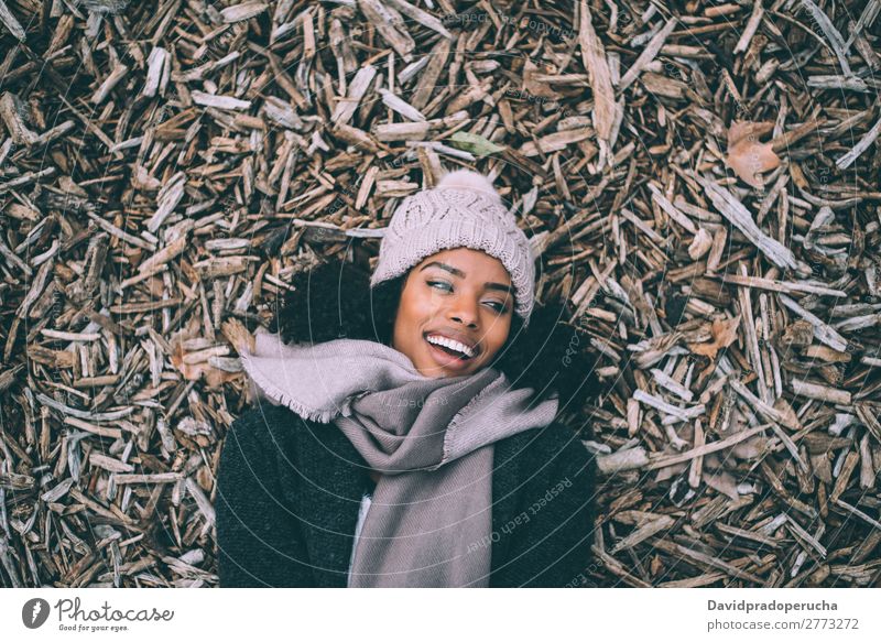 Junge schwarze schöne Frau, die im Winter auf Waldstücken in der Nähe des Königspalastes in Madrid liegt. Ferien & Urlaub & Reisen Großstadt Stadt Zentrum Holz
