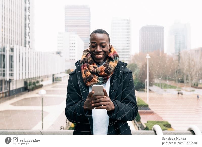 Geschäftsmann auf der Straße. Mann schwarz Afrikanisch Amerikaner Business Handy Jugendliche Telefon Glück Mobile Außenaufnahme PDA Texten Mitteilung Tippen