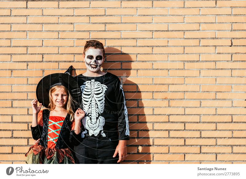 Porträt von Kindern, die auf der Straße verkleidet sind. Halloween Mädchen Junge malen Skelett Hexe Freude Familie & Verwandtschaft Schwester Freundschaft
