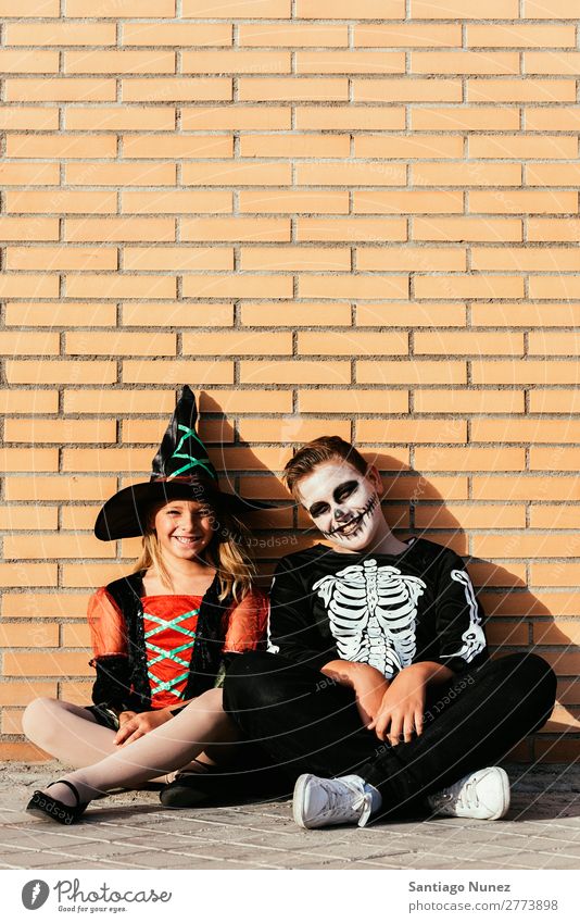 Porträt von Kindern, die auf der Straße verkleidet sind. Halloween Mädchen Junge malen Skelett Hexe Freude Familie & Verwandtschaft Schwester Freundschaft