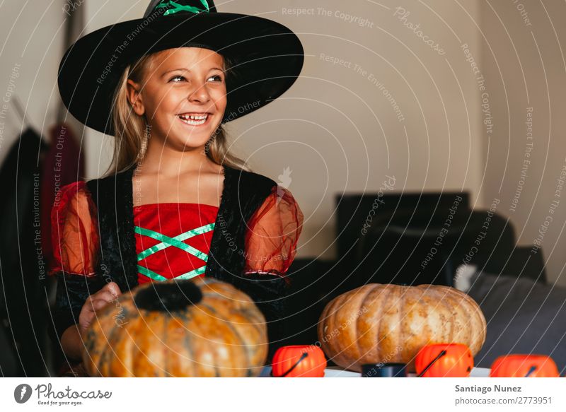 Schönes Mädchen verkleidet von einer Hexe, die zu Hause einen Kürbis schmückt. Halloween Kind malen Freude Familie & Verwandtschaft Schwester Porträt Angst
