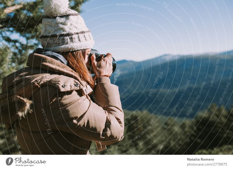 brünettes Mädchen mit Wollmütze und braunem Mantel macht ein Foto. Lifestyle Gesundheit Leben Freizeit & Hobby wandern Fotokamera Technik & Technologie Mensch