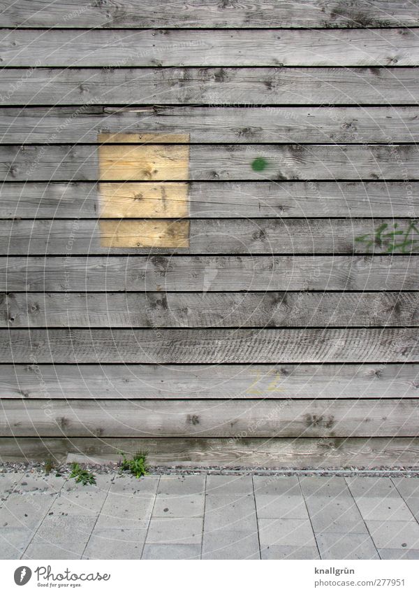 Vergangenheit Holzwand alt eckig braun grau Bodenplatten Rechteck Astloch Farbfoto Gedeckte Farben Außenaufnahme Menschenleer Textfreiraum rechts