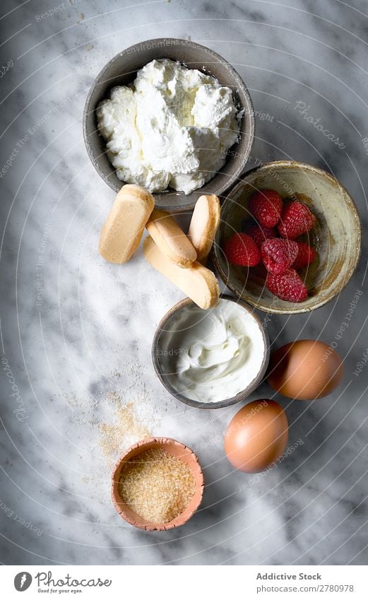 Draufsicht auf die Kuchenzutaten auf dem Tisch Zutaten frisch Produkte Kekse Himbeeren Creme Entwurf Ei Zucker Zusammensetzung Marmor Ordnung Lebensmittel
