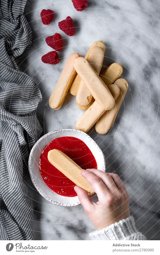 Getreideperson, die Himbeerkekse herstellt. kochen & garen Himbeeren Kekse Marmelade eintauchend süß rot Zusammensetzung Frucht Kuchen backen Gesundheit frisch