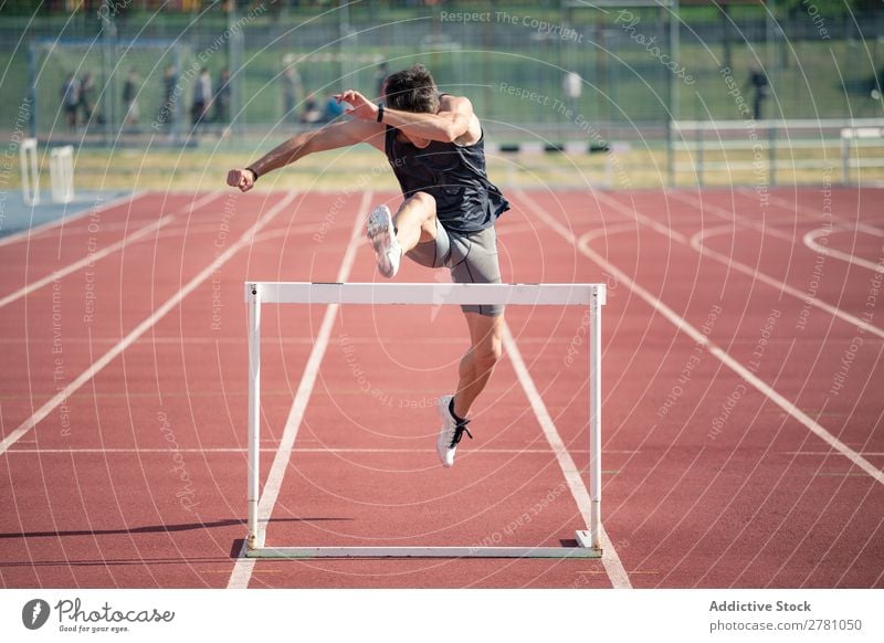 Mann springt über die Hürde rennen Rennbahn Athlet Bahn Tatkraft Konkurrenz wettbewerbsfähig Läufer Geschwindigkeit Feld Hürdenlauf konkurrieren Außenaufnahme