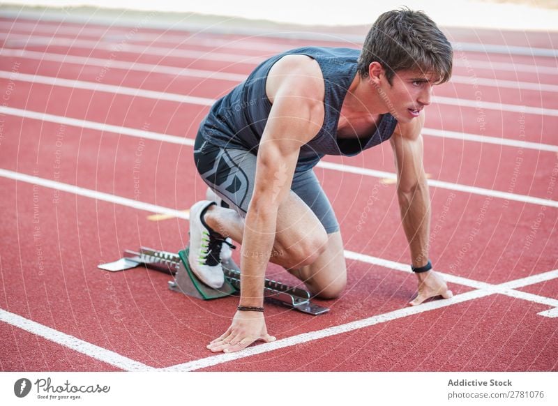 Sportler am Kauerstart Läufer Rennbahn Sprinter Stadion Biegen Fitness üben Athlet muskulös Erwachsene Sportbekleidung sportlich Jugendliche Außenaufnahme