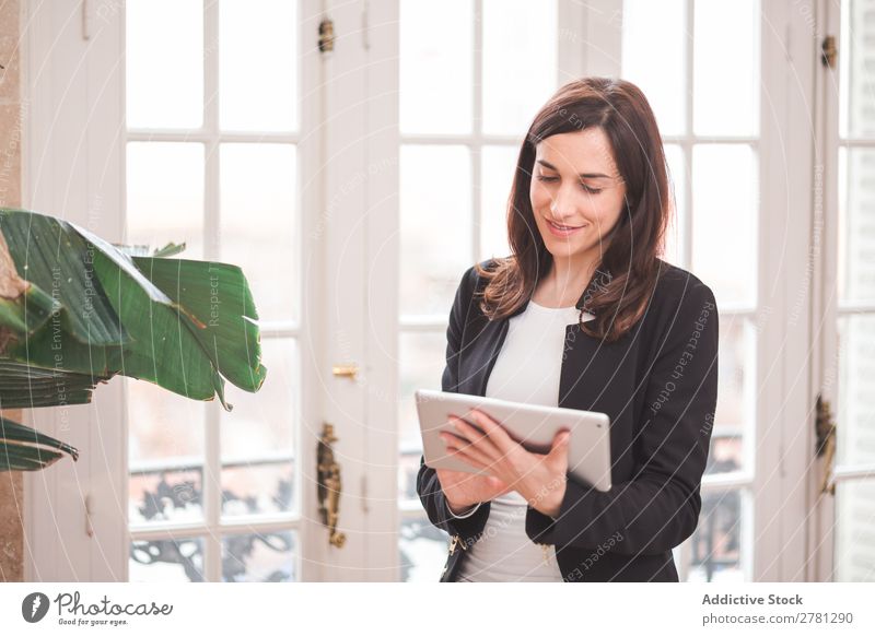Junge lächelnde Frau stehend mit Tablette Tablet Computer Lächeln Technik & Technologie Körperhaltung heiter Apparatur modern digital Geschäftsfrau Unternehmer