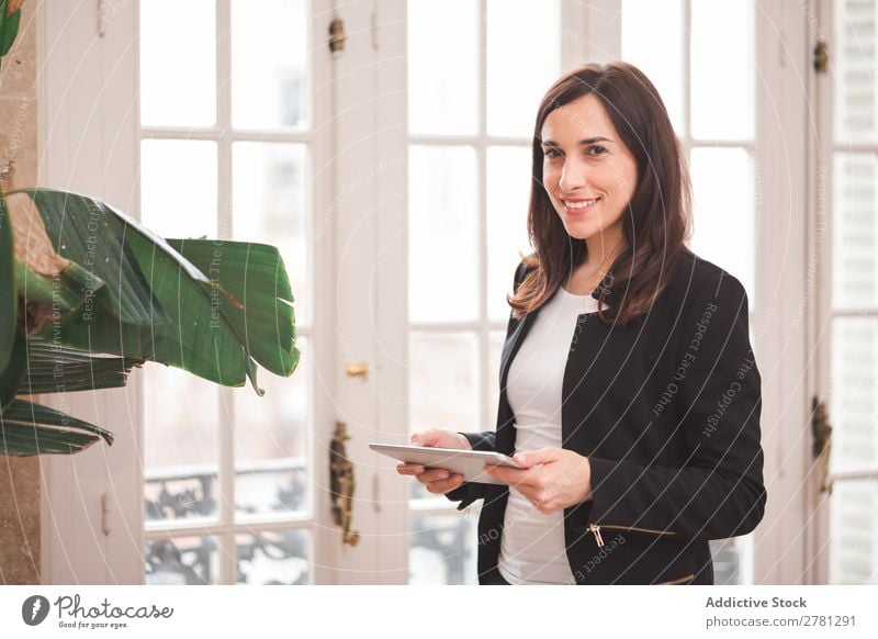 Junge lächelnde Frau stehend mit Tablette Tablet Computer Lächeln Technik & Technologie Körperhaltung heiter Apparatur modern digital Geschäftsfrau Unternehmer