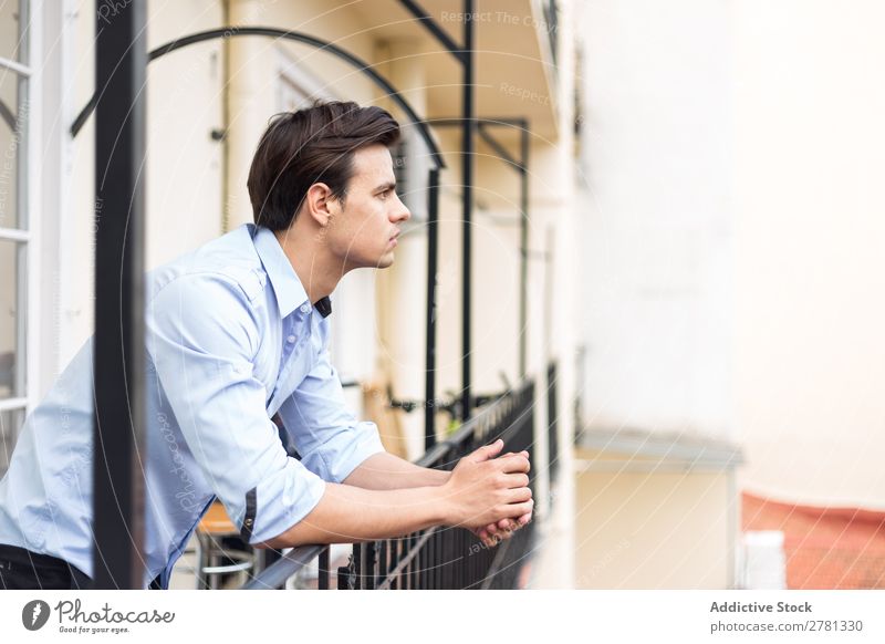 Junger seriöser Mann im blauen Hemd posierend ernst stehen Balkon Porträt gestikulieren Fürsorge besinnlich Körperhaltung Mensch 1 Jugendliche Erwachsene