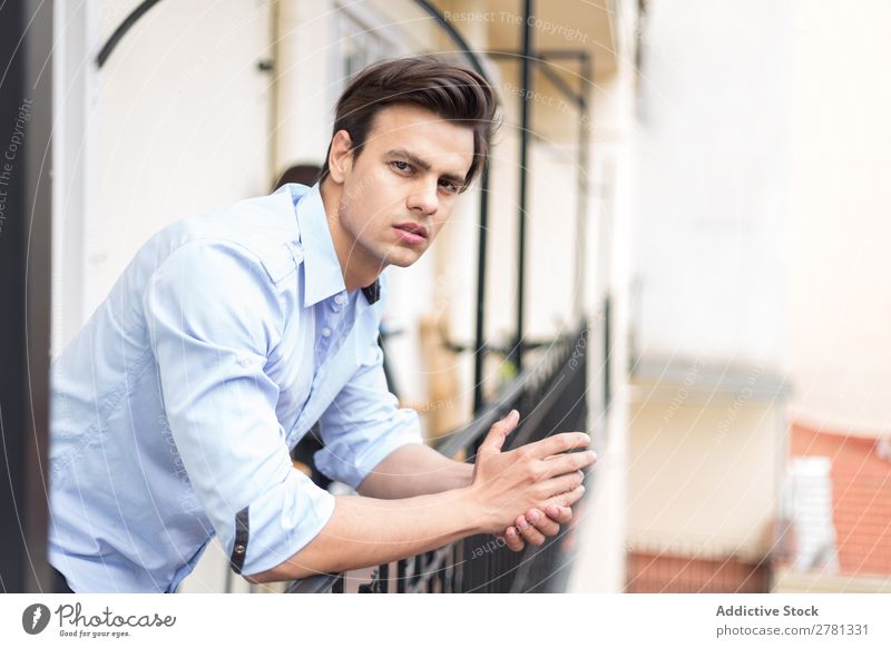Junger seriöser Mann im blauen Hemd posierend ernst stehen Balkon Porträt gestikulieren Fürsorge besinnlich Körperhaltung Mensch 1 Jugendliche Erwachsene