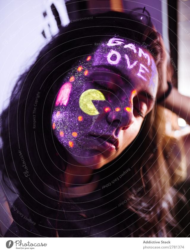 Spielerin mit fluoreszierender Farbe Frau Jugendliche hübsch Spielfeld Konsole Augen geschlossen Regler malen leuchten erleuchten Kunst neonfarbig Licht Mode