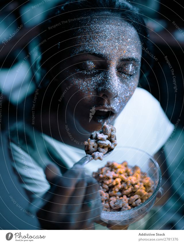 Frau mit Glitzer auf dem Gesicht beim Getreide essen Jugendliche hübsch Farbe malen Essen Müsli Lebensmittel Frühstück grau fluoreszierend leuchten erleuchten