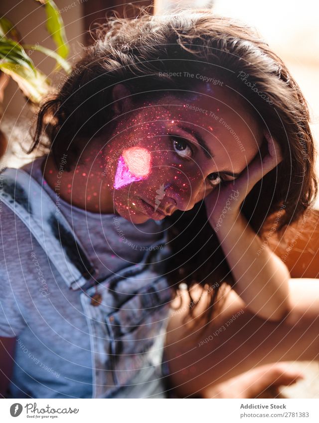 Frau mit unterschiedlicher Leuchtfarbe auf dem Gesicht Jugendliche hübsch Farbe malen außergewöhnlich fluoreszierend leuchten erleuchten Kunst neonfarbig Licht