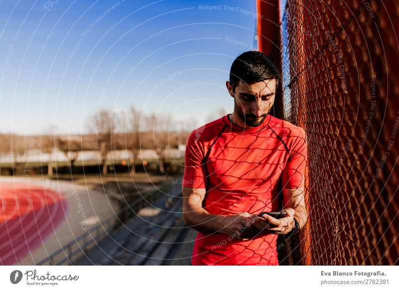 junger Läufer Mann mit Handy Lifestyle Freizeit & Hobby Sport Sportler Stadion Technik & Technologie Mensch maskulin Junger Mann Jugendliche Erwachsene 1