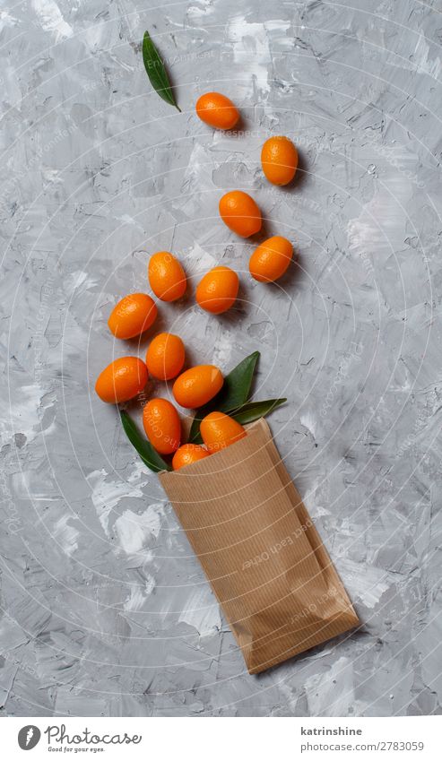 Kumquat-Früchte auf grauem Hintergrund Frucht Dessert Ernährung Vegetarische Ernährung Diät exotisch Menschengruppe Blatt Papier frisch natürlich oben saftig