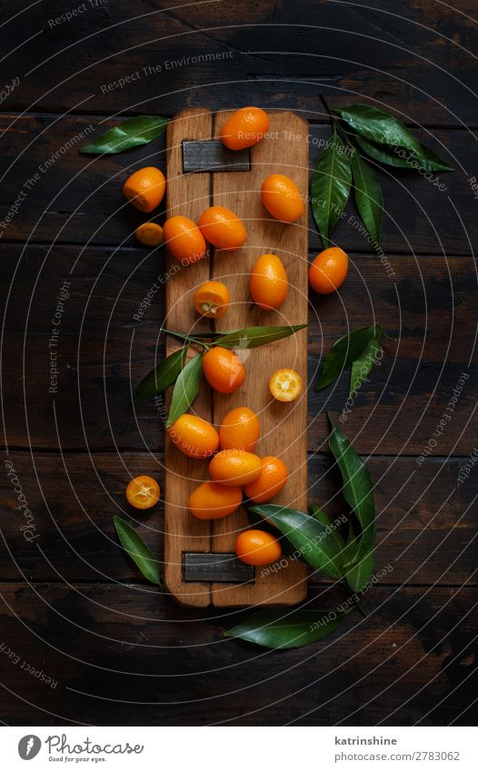 Kumquat-Früchte auf dunklem Holzgrund Frucht Dessert Ernährung Vegetarische Ernährung Diät exotisch Menschengruppe Blatt dunkel frisch natürlich oben saftig