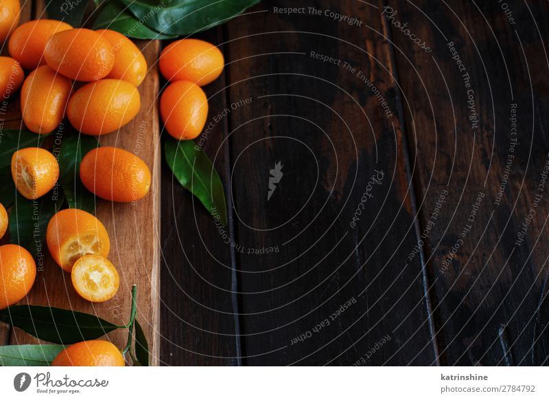 Kumquat-Früchte auf dunklem Holzgrund Frucht Dessert Ernährung Vegetarische Ernährung Diät exotisch Menschengruppe Blatt dunkel frisch natürlich saftig braun