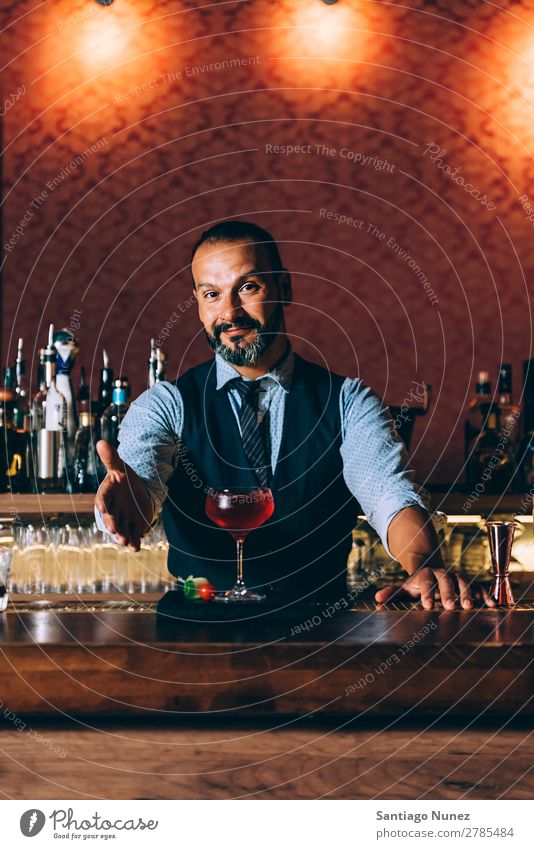 Barman macht Cocktails im Nachtclub. Schüttler Barmann Barkeeper Kellnern Mann Porträt Porträtmalerei rühren Mixologe Hinzufügen Alkohol Aufschlag Business Club