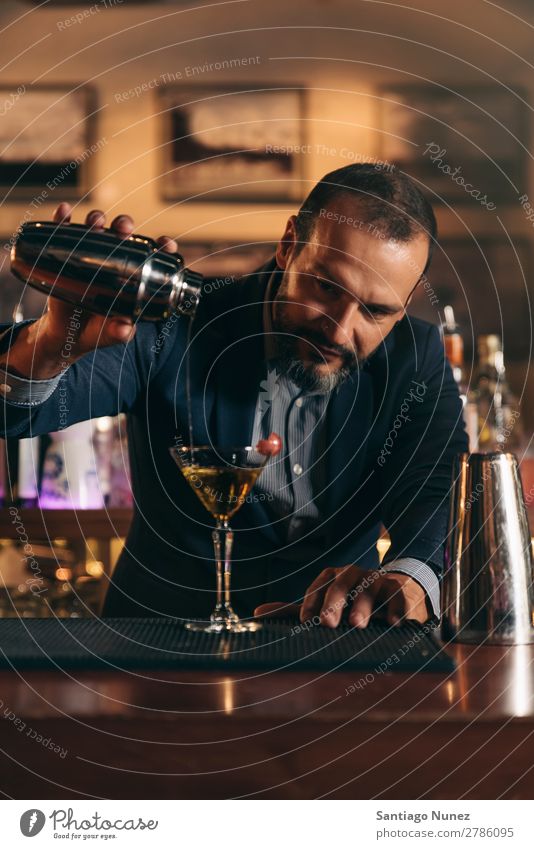 Barman macht Cocktails im Nachtclub. Schüttler Barmann Barkeeper Kellnern Mann rühren Mixologe Hinzufügen Alkohol Business Club trinken professionell Pub