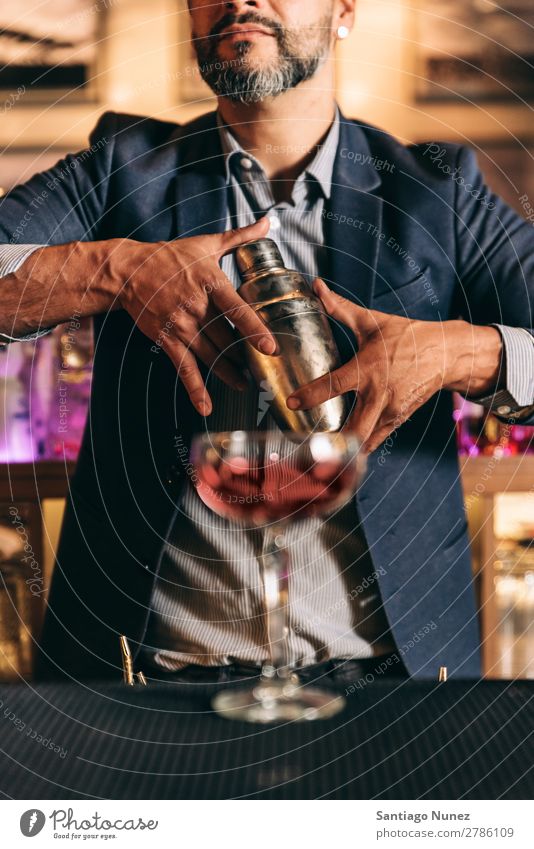 Barman macht Cocktails im Nachtclub. Schüttler Barmann Barkeeper Kellnern Mann rühren Mixologe Hinzufügen Alkohol Business Club trinken professionell Porträt