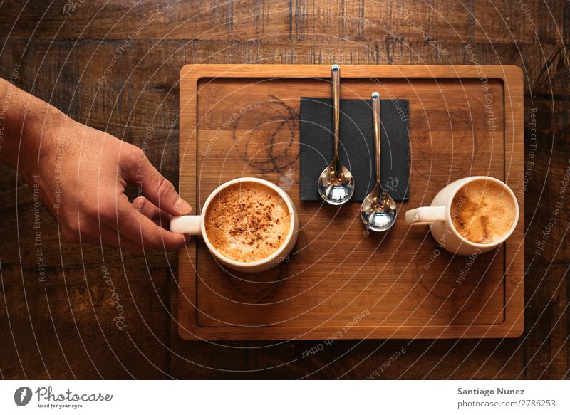 Der Kellner hält ein Tablett mit Kaffee. Kellnern Kantine Portion Café Barista kaufen Angebot Tasse schließen Aufschlag nach oben Server Jugendliche Aussicht
