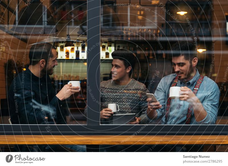 Freunde trinken Kaffee und plaudern. Mann Freundschaft Jugendliche Teamwork Menschengruppe Lifestyle PDA Handy Mobile Mitteilung benutzend Text Computer
