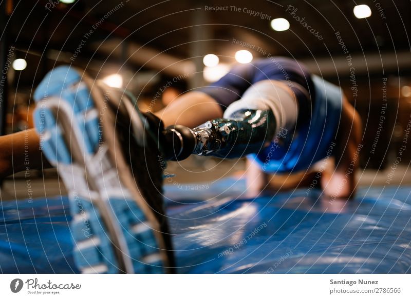 Behinderter junger Mann beim Training in der Turnhalle Jugendliche Athlet Sport prothetisch deaktiviert hochschieben paralympisch Fitness Sporthalle Aktion