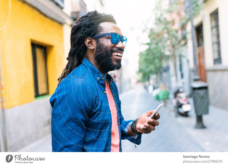 Afrikanischer junger Mann benutzt Handy auf der Straße Lifestyle hören schwarz Amerikaner Stadt Porträt Telefon PDA Mobile Solarzelle Mitteilung Texten E-Mail
