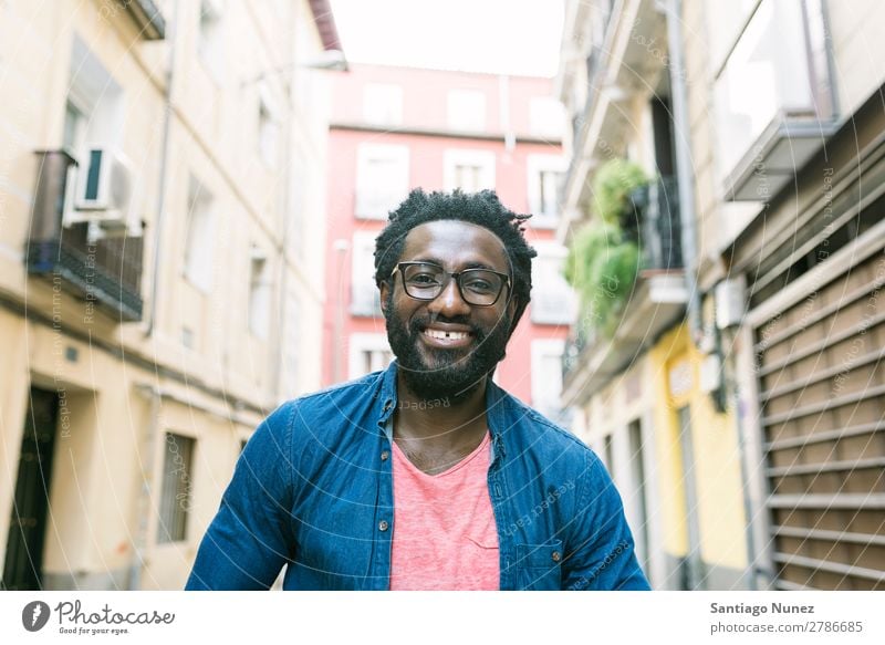 Ein junger Afrikaner auf der Straße. Mann Afrikanisch Lifestyle hören schwarz Amerikaner Stadt Porträt gutaussehend stehen Schickimicki Rastalocken