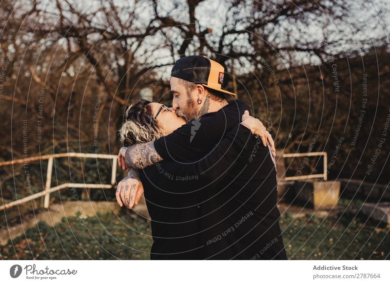Junges Paar, das sich im Wald umarmt und küsst. Umarmen Küssen Park Jugendliche Brille bärtig Mann Frau umarmend Schickimicki laufen romantisch Sonne