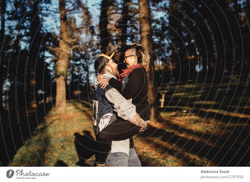 Glückliches junges Paar umarmt sich im Park Umarmen Baum Holz Hand Wald Jugendliche heiter bärtig Mann gehen Frau Freude umarmend Schickimicki laufen romantisch