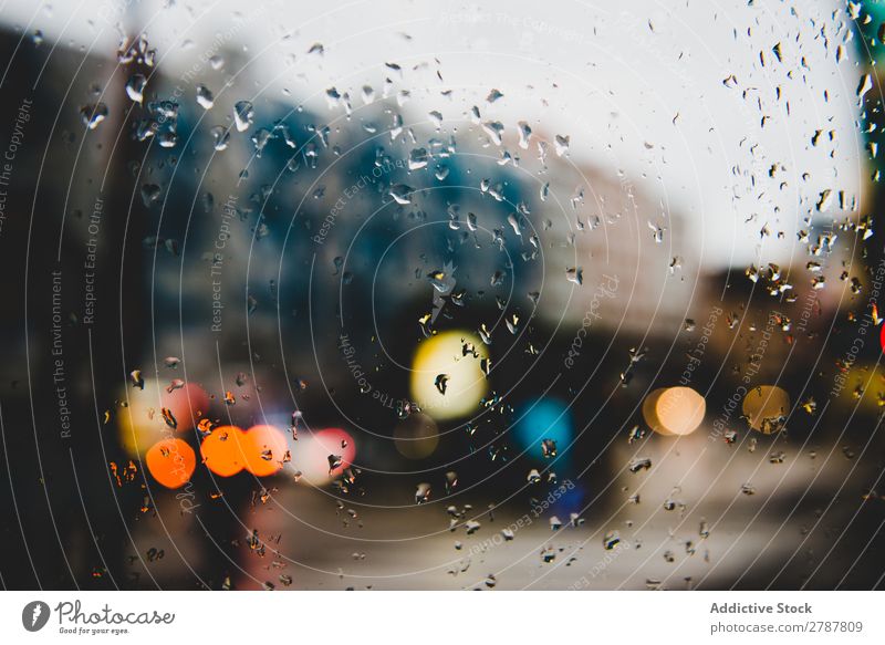 Straße mit Beleuchtung durch Glas mit Spots Licht Fleck Regen Fenster Großstadt nass Glanz Stadt abstrakt Aussicht Loft Entwurf Gebäude trist modern Abend