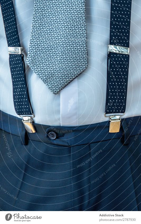Mann mit Hosenträgern an Hose und Krawatte Blick anhaben Anzug Entwurf blau Hemd Stil Mode Bekleidung Accessoire trendy formell elegant Stoff modisch Design