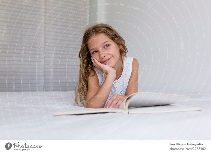 schönes Kind Mädchen liest ein Buch auf dem Bett Lifestyle Freude Erholung Freizeit & Hobby lesen Haus Schlafzimmer Schule lernen Schulkind Student feminin
