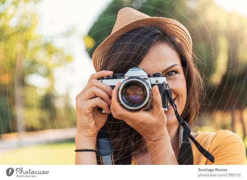 Lächelnde junge Frau, die eine Kamera benutzt, um Fotos zu machen. Fotograf Fotografie Fotokamera Jugendliche Mädchen digital weiß Freizeit & Hobby 1 nehmen