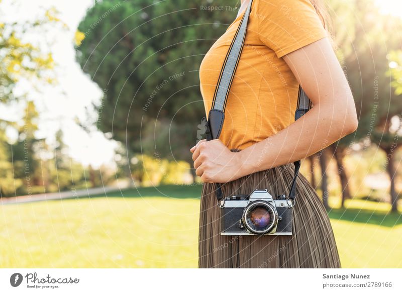 Nahaufnahme eines Fotografen mit seiner Kamera. Fotokamera professionell Fotografie analog Tasche lässig Freizeitkleidung reflektorisch kaukasische Ethnizität