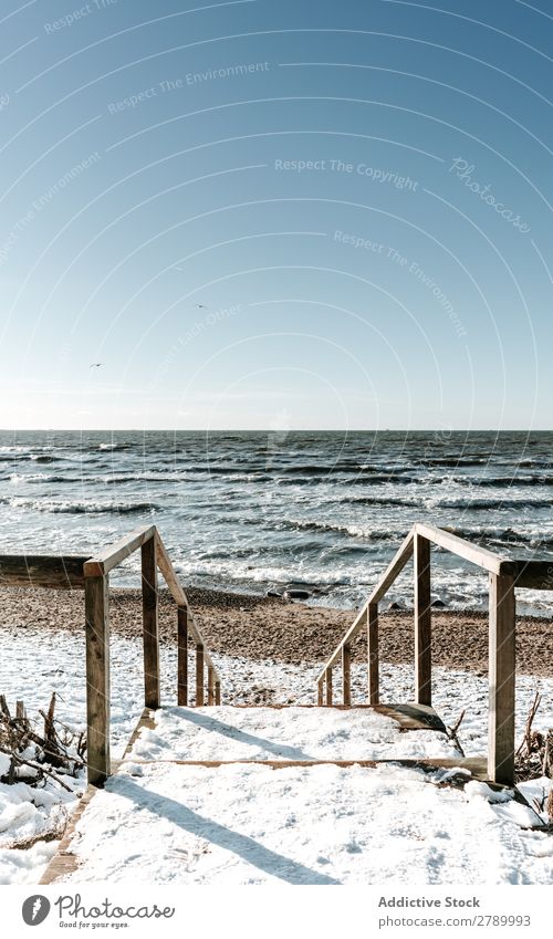 Treppe im Schnee, die zum Meeresufer führt. Küste Litauen Klappeda Holz Schritt Winter Wasser blau Himmel führend Himmel (Jenseits) kalt Eis Natur Landschaft