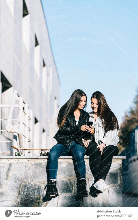 Mädchen, die ein Handy benutzen Wand Technik & Technologie Erwachsene Blick Jugendliche gutaussehend Fensterbrett Teamwork Amerikaner sitzen Freude lässig