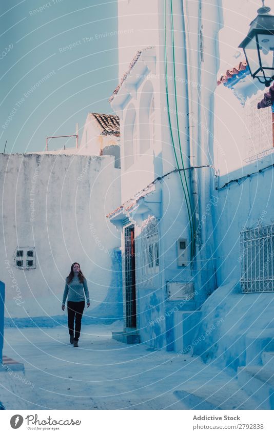 Touristenfrau, die auf einer weißen Straße spazieren geht. Frau Marokko Chechaouen Tradition Ferien & Urlaub & Reisen Kultur Großstadt arabisch Stadt mehrfarbig