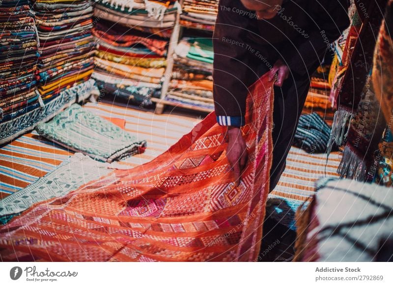Verkäufer zeigt Teppich auf dem Markt zeigen Geschenk rot Wahl pflücken Osten Basar Tradition kaufen Lager Tourismus mehrfarbig Chechaouen Marokko Sale
