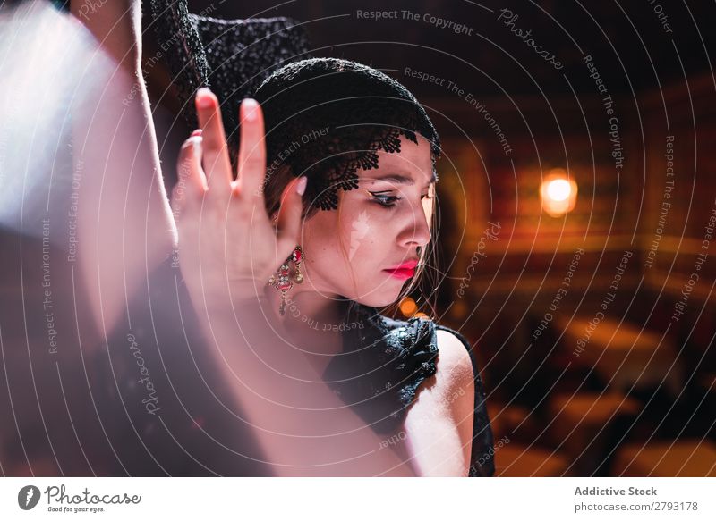 Frau in Kleid mit hochgezogener Hand tanzt in der Szene. Tanzen erhöht Show Dame künstlerisch Flamencotänzer schön Innenarchitektur Jugendliche attraktiv Lampe
