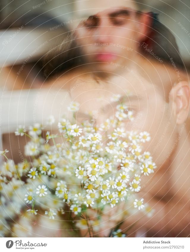 Junger Mann mit einem Blumenstrauß in den Händen. Mund Haufen Typ frisch Jugendliche brünett weiß ohne Hemd Überraschung Geschenk romantisch Gänseblümchen
