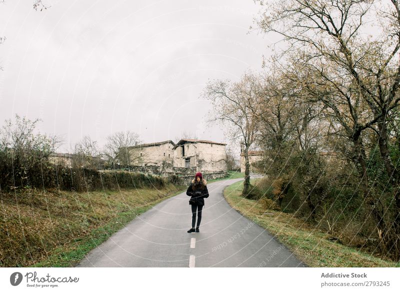 Frau in Mantel mit Kamera auf der Straße Fotokamera Orduna Spanien Hand Tasche Hut Winter anhaben Dame Jugendliche Landschaft Wege & Pfade