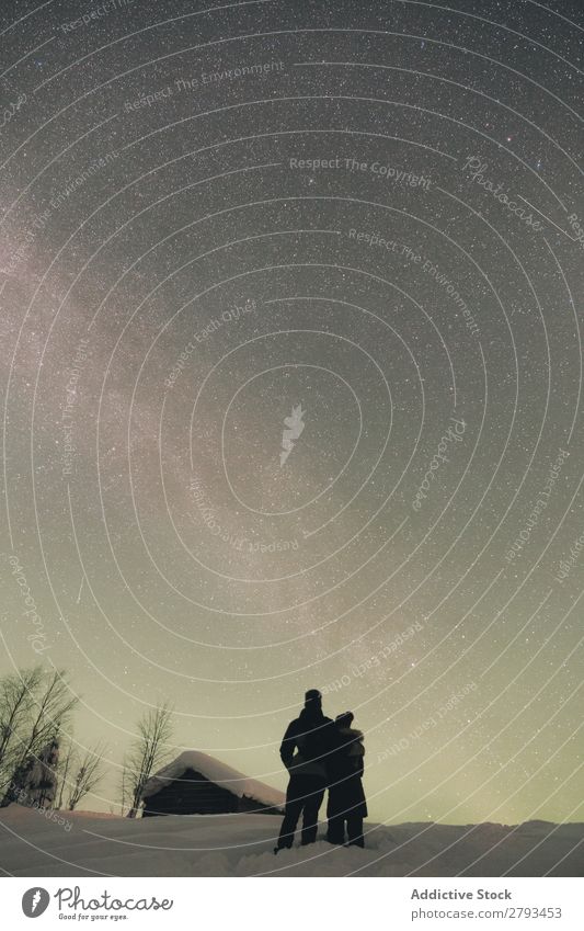 Anonymes Paar mit Blick auf den Nachthimmel bewundernd Himmel Arktis Landschaft umarmend Liebe Zusammensein Abend Ferien & Urlaub & Reisen Schnee kalt Wetter