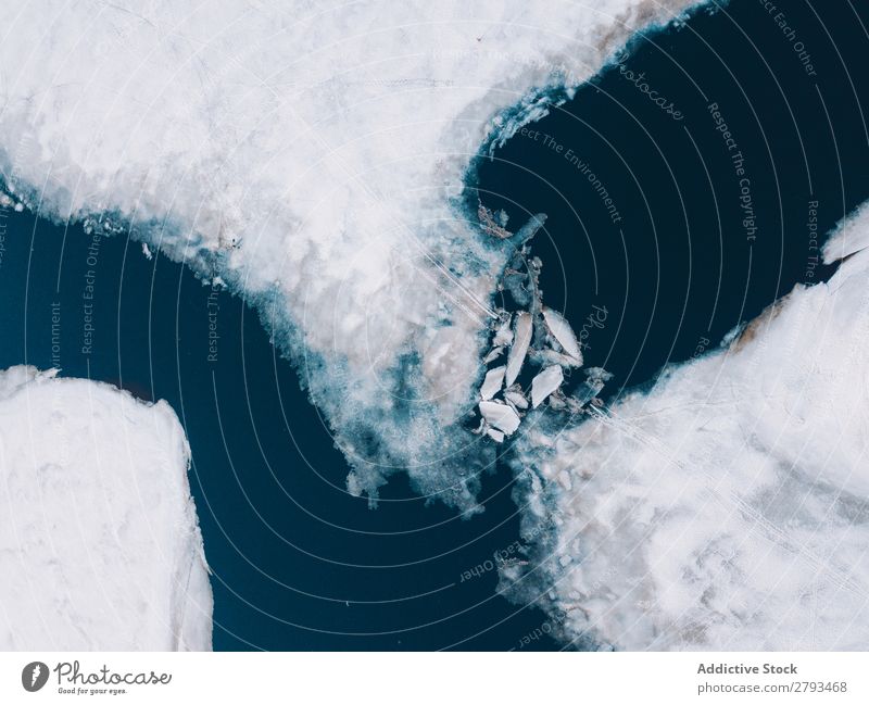 Eisplatten in der Nähe von schneebedeckten Ufern Platten Wasser Arktis Küste Schnee kalt kaputt Oberfläche Meer Frost Schaden Coolness dunkel Menschenleer