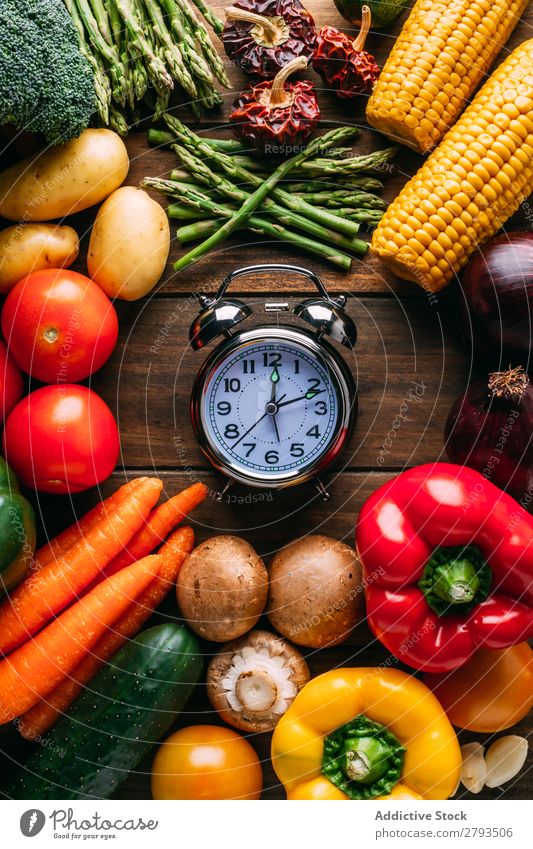 Gemüse, das um den Wecker herum liegt. Zeit Tisch Diät Entwurf Lebensmittel Gesundheit Ernährung organisch Vegane Ernährung Kulisse sortiert Verschiedenheit
