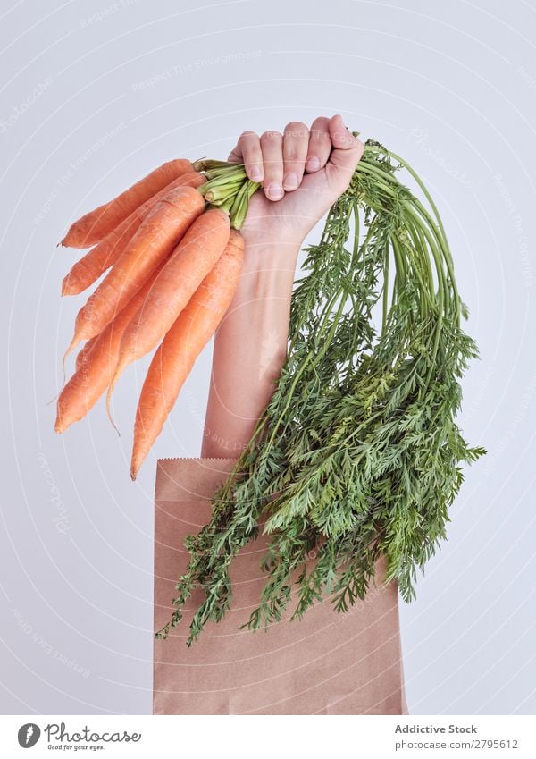 Personenhand aus der Packung ausgestreckt und Karotten haltend Mensch Hand Möhre Paket sich[Akk] gemeldet Gemüse Lebensmittel Tasche Handwerk Papier Entwurf