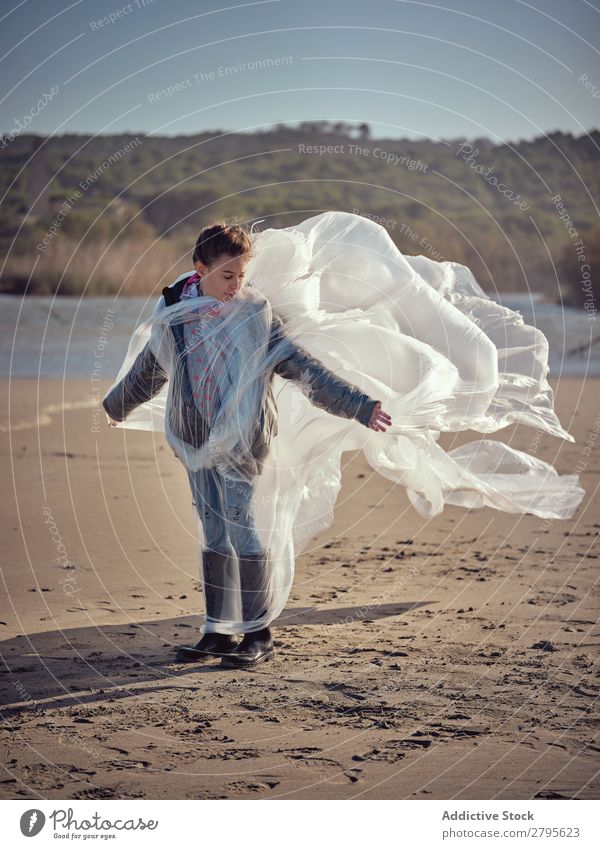 Mädchen in Plastik verstrickt an der Flussküste Kunststoff Textil winkend Küste Seite Wind Sand Wasser Berge u. Gebirge Landschaft Strand Hilfsbereitschaft weiß