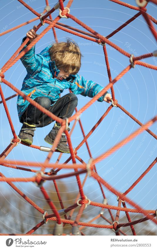 Kind klettert auf dem Spielplatz Mensch Junge Kindheit 1 3-8 Jahre Himmel Wolkenloser Himmel Frühling Schönes Wetter Bewegung Spielen authentisch Glück